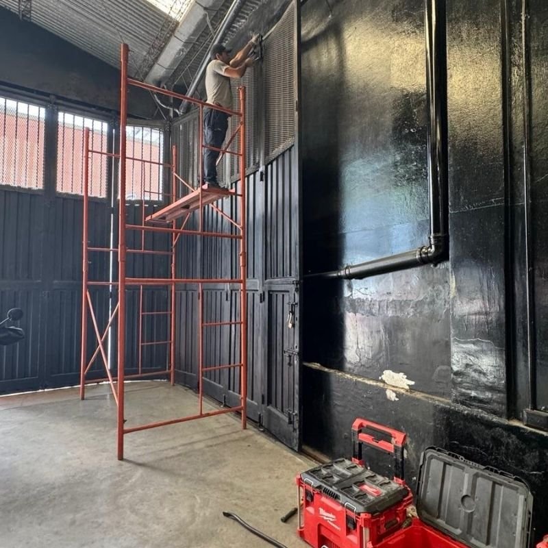 Cambio de carros y rolletes en portón curvo-corredizo. Sustitución de los carros superiores y de los rolletes inferiores en un portón curvo-corredizo, utilizando andamiaje por su gran tamaño. Trabajo realizado por HERREELEC.